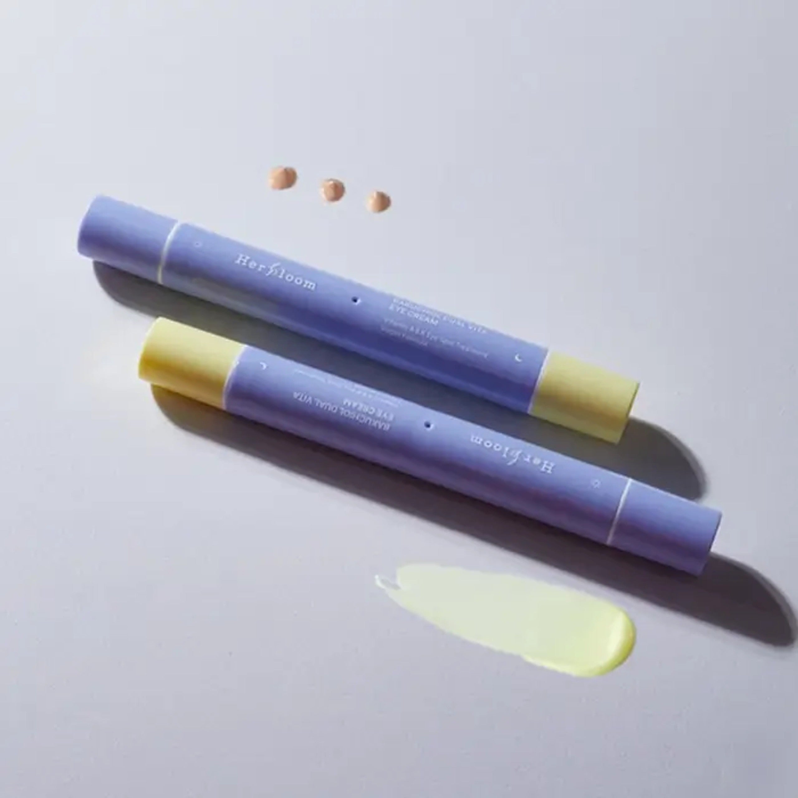 HERBLOOM Bakuchiol Dual Vita Eye Cream tubes with cream swatch on white background