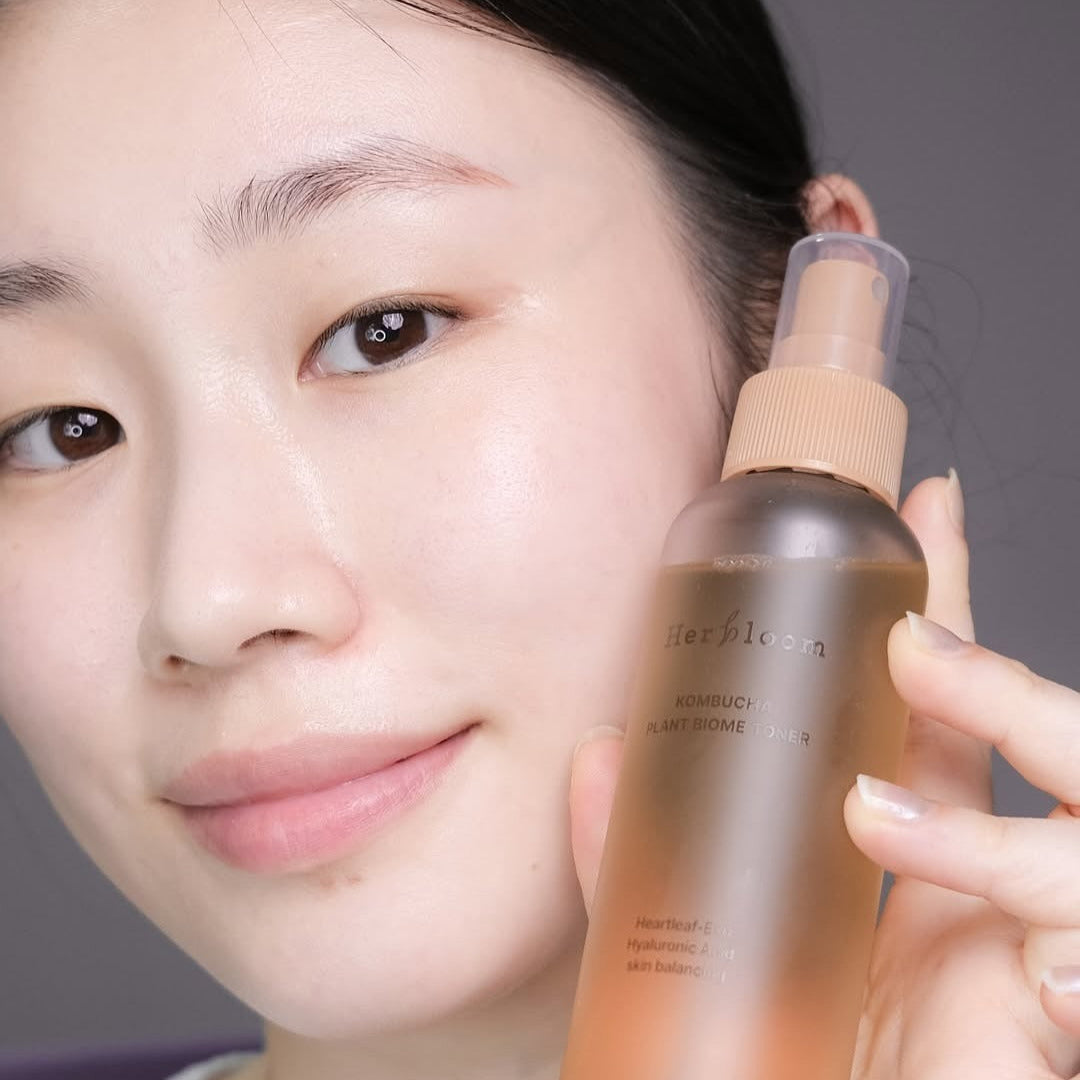HERBLOOM Kombucha Plant Biome Toner 150g bottle held by person with clear skin, highlighting natural skincare benefits.
