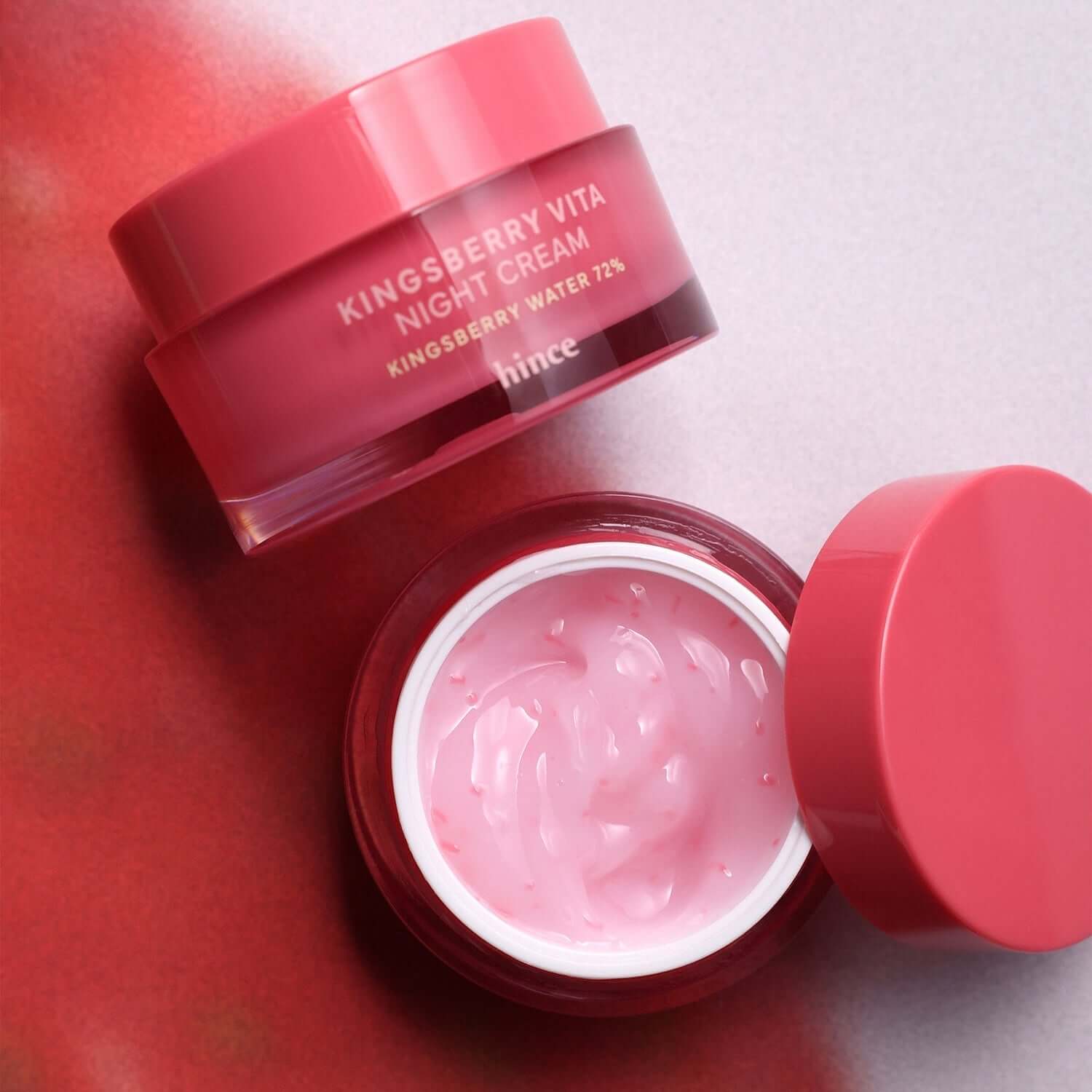 HINCE Kingsberry Vita Night Cream in pink jar with open lid on a red background.