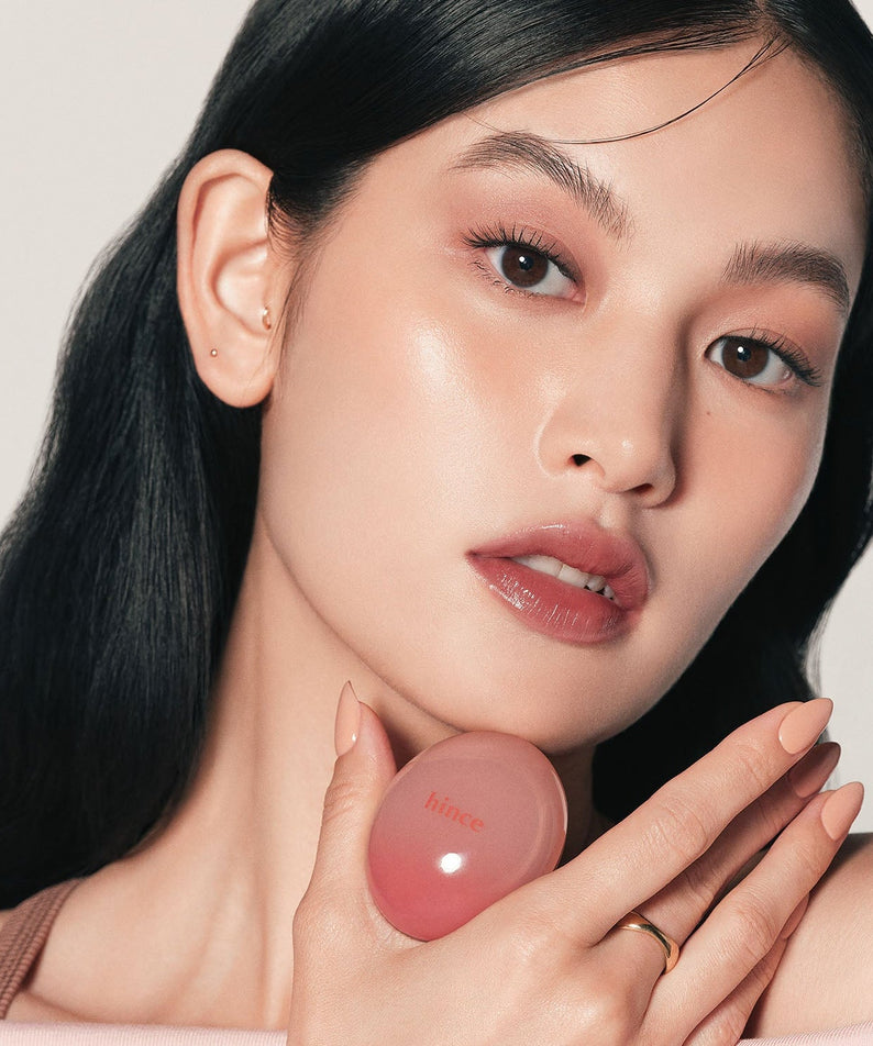 Woman holding HINCE Low Glow Dewy Ball (Lip&Cheek) for a natural makeup look