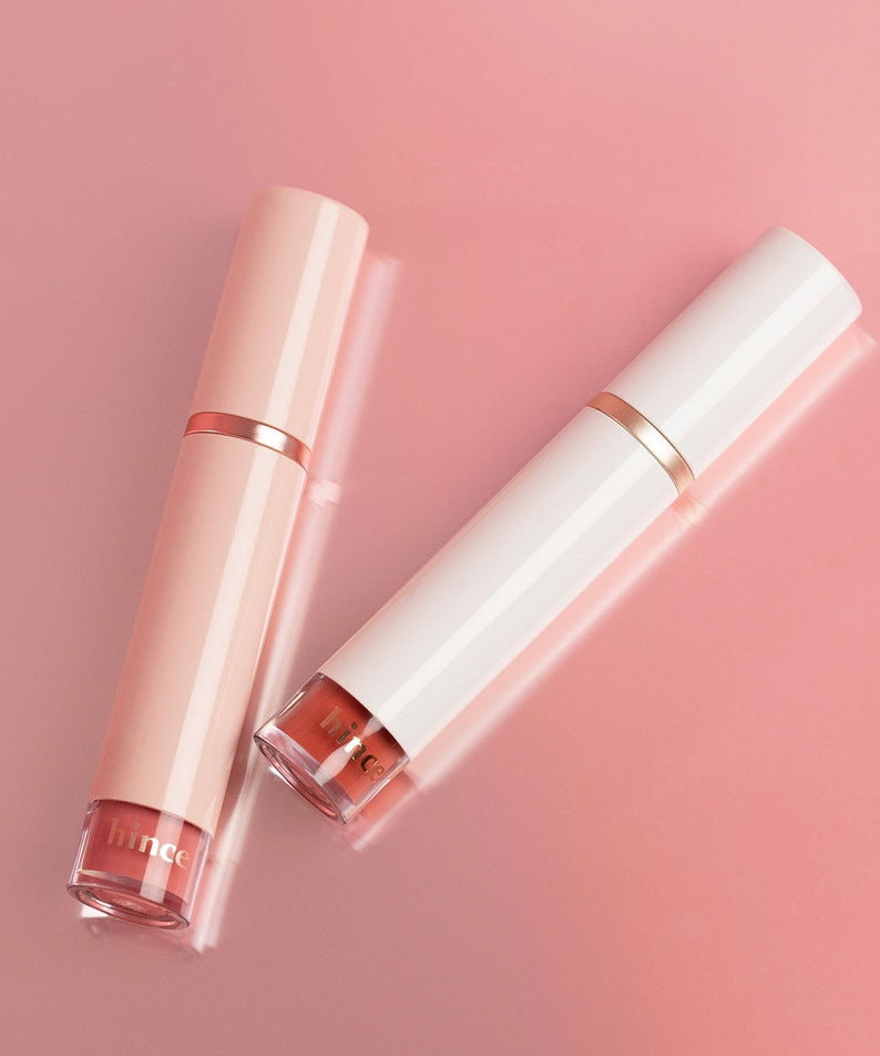 HINCE Mood Enhancer Water Liquid Glow in elegant peach and white packaging on a pink background