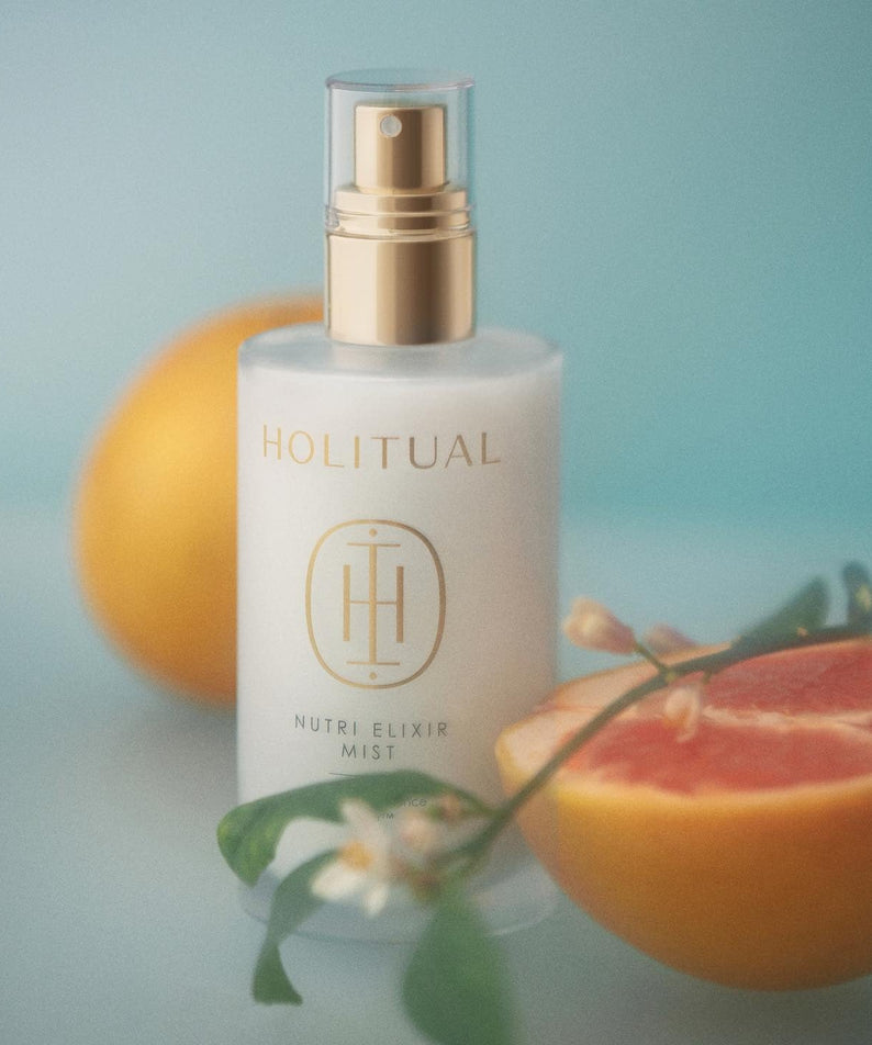 HOLITUAL Elixir Mist 140ml bottle with citrus and floral elements, showcasing the luxury skincare product.