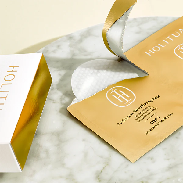 HOLITUAL Radiance Resurfacing Peel packaging and product displayed on a marble surface, showcasing exfoliating pads for radiant skin.