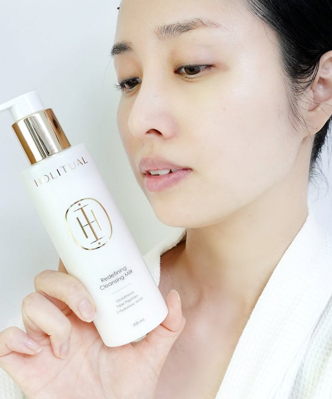 Woman holding HOLITUAL Redefining acleansing Milk 200ml