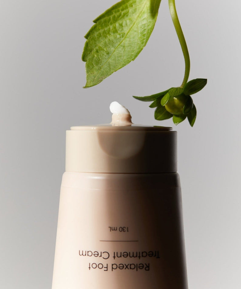 HOLITUAL Relaxed Foot Treatment Cream 130ml with plant decoration on gray background