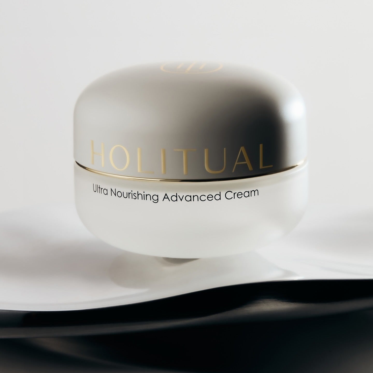 HOLITUAL Ultra Nourishing Advanced Cream in an elegant jar on a soft fabric background