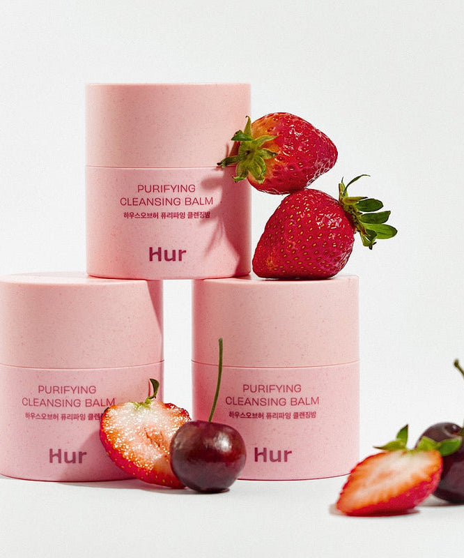 HOUSE OF HUR Purifying Cleansing Balm with fresh strawberries and cherries, skincare product in pink packaging.
