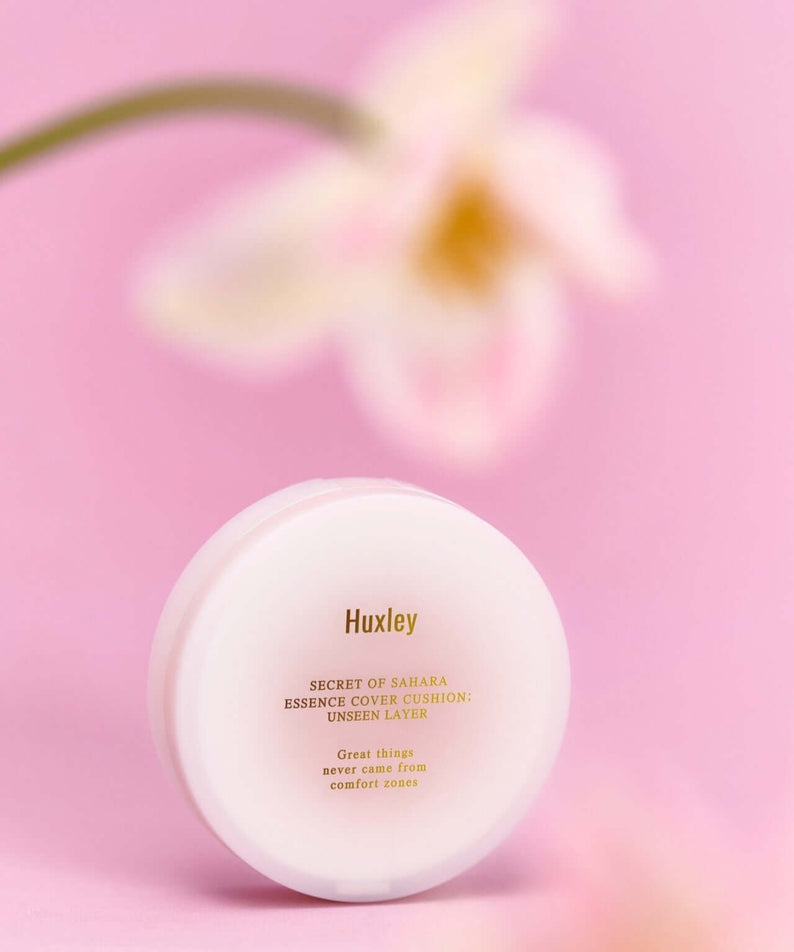 HUXLEY Essence Cover Cushion Unseen Layer with flower background, enhancing natural beauty and moisturization.
