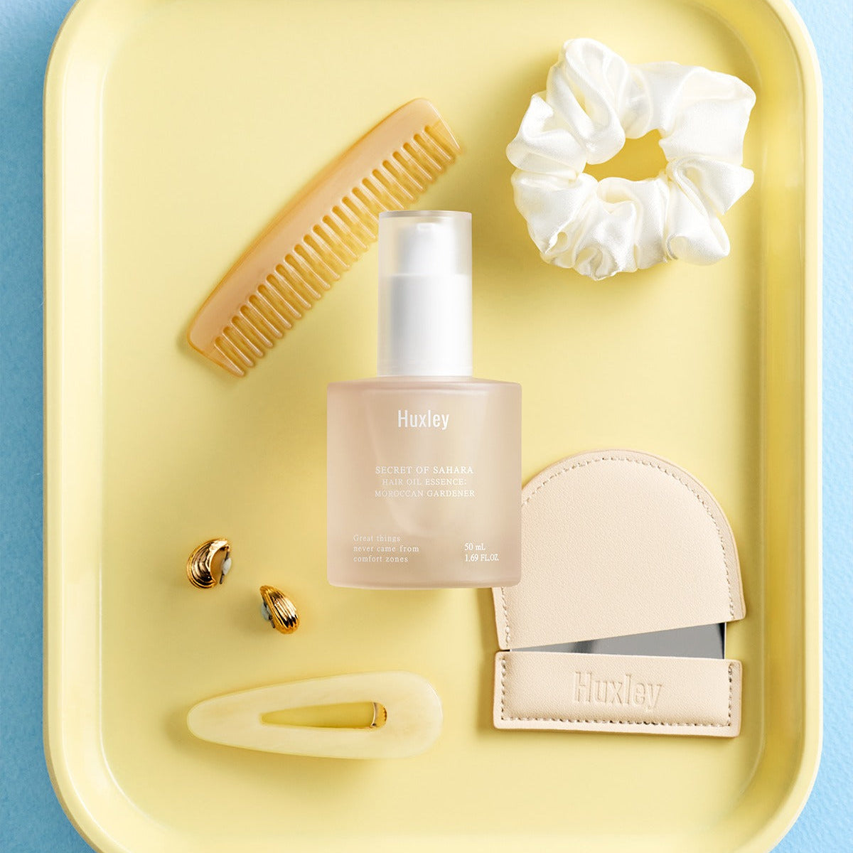 HUXLEY Hair Oil Essence Moroccan Gardener 50ml displayed with hair accessories.