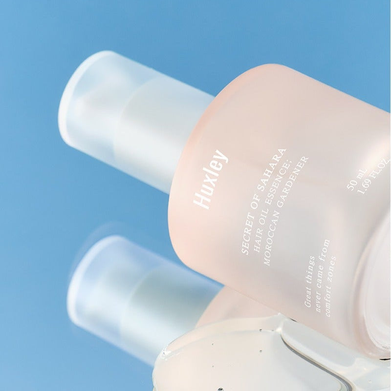 HUXLEY Hair Oil Essence Moroccan Gardener 50ml bottle against a blue background.