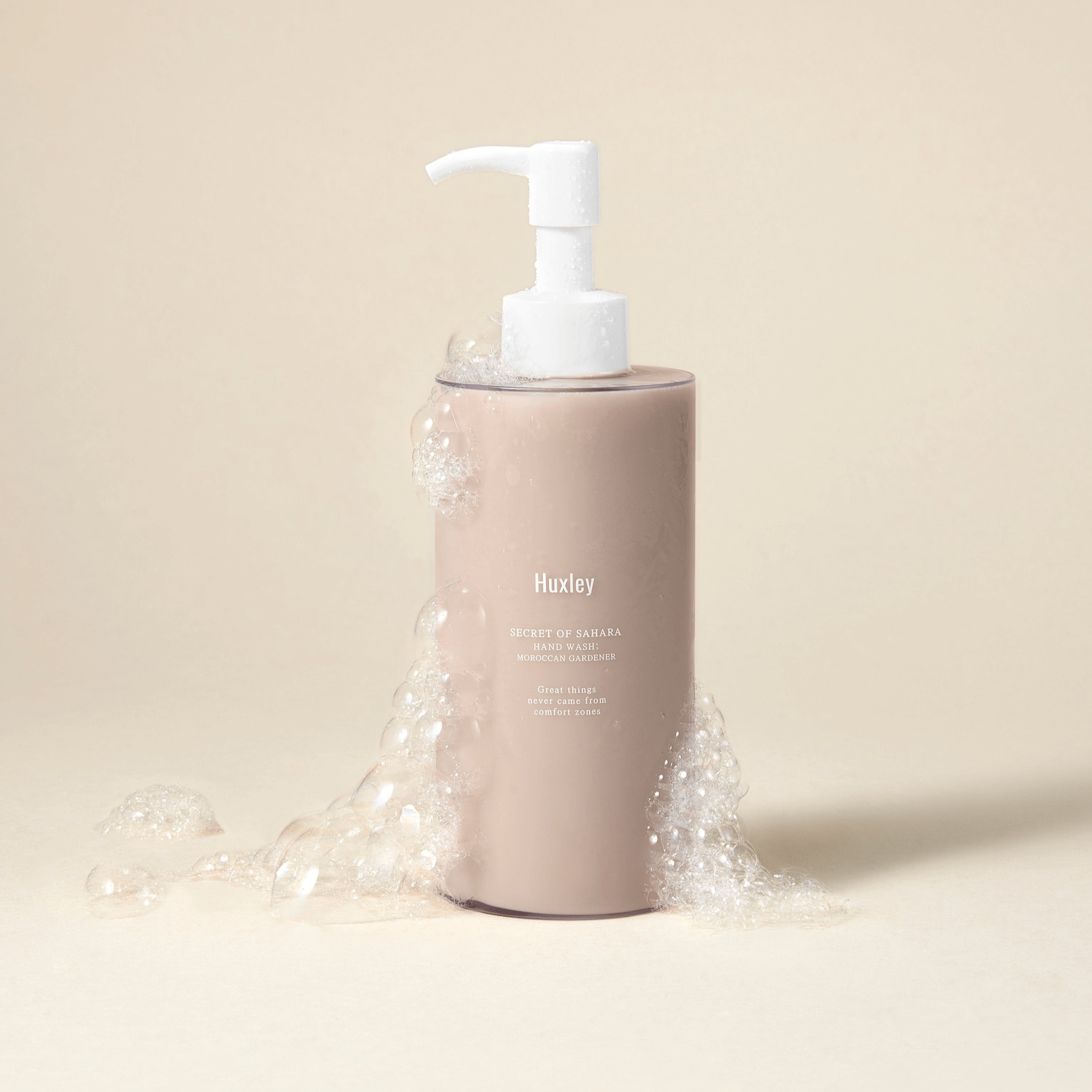 HUXLEY Hand Wash Moroccan Gardener bottle with bubbles on a neutral background.