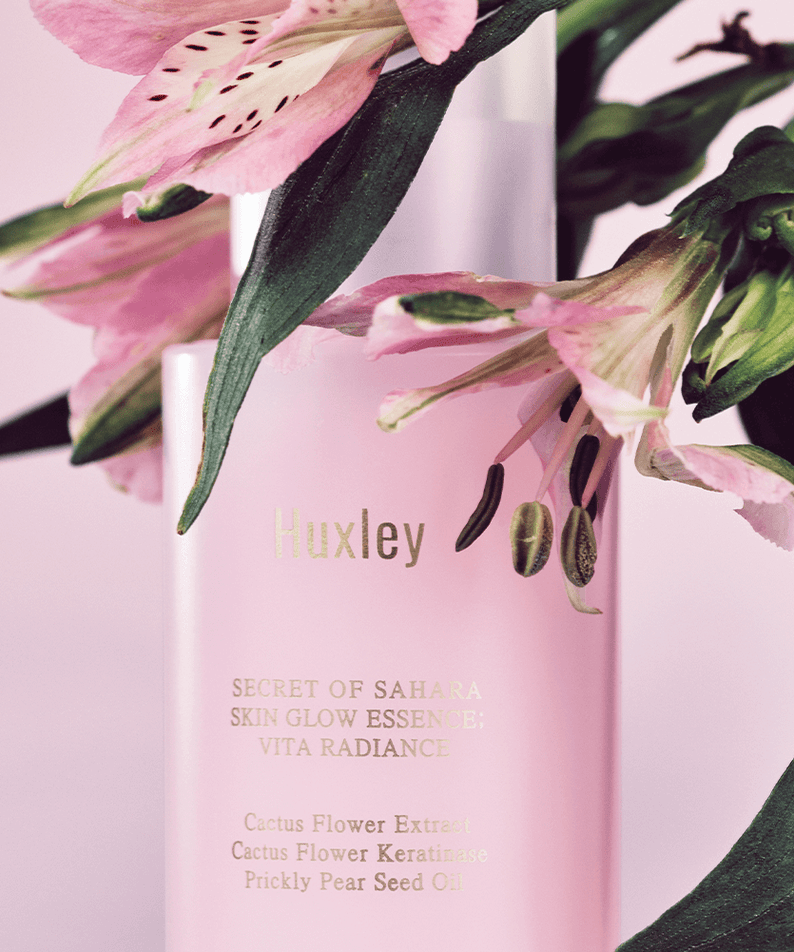 HUXLEY Skin Glow Essence Vita Radiance bottle with floral accents, highlighting the essence's radiance and vitality benefits.