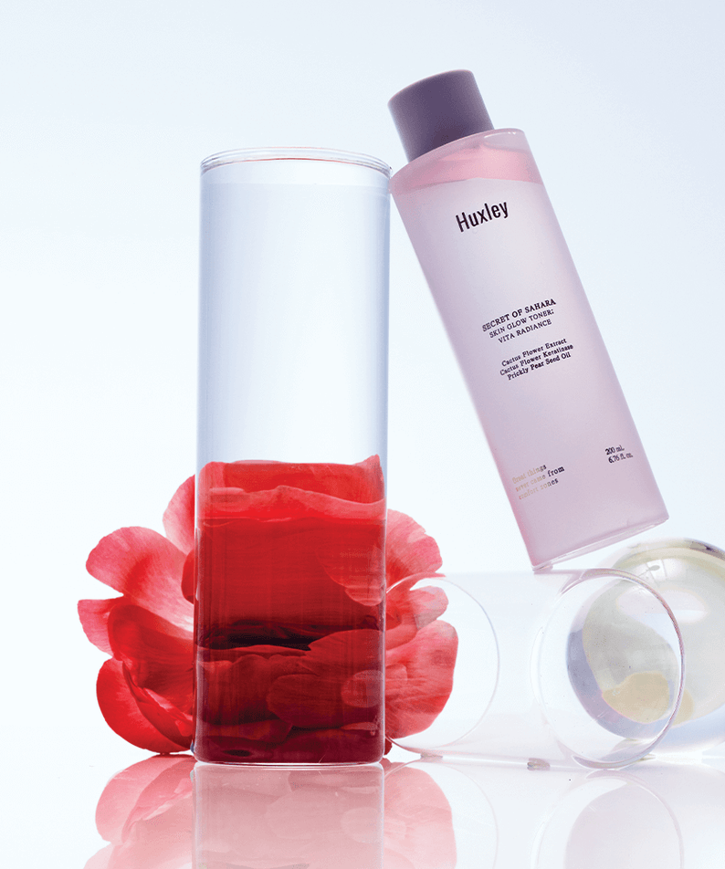 HUXLEY Skin Glow Toner Vita Radiance bottle with clear liquid and petals, promoting radiant skin.