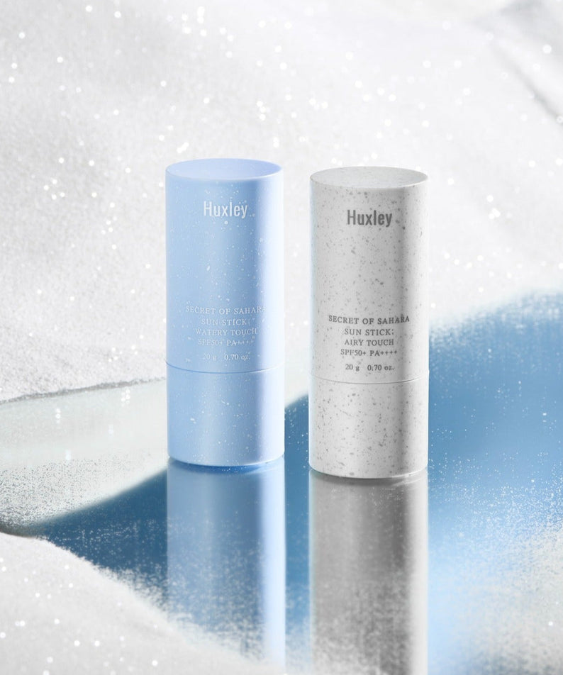 HUXLEY Sun Stick Airy Touch 20g on reflective snowy surface, featuring blue and white packaging for sun protection skincare.