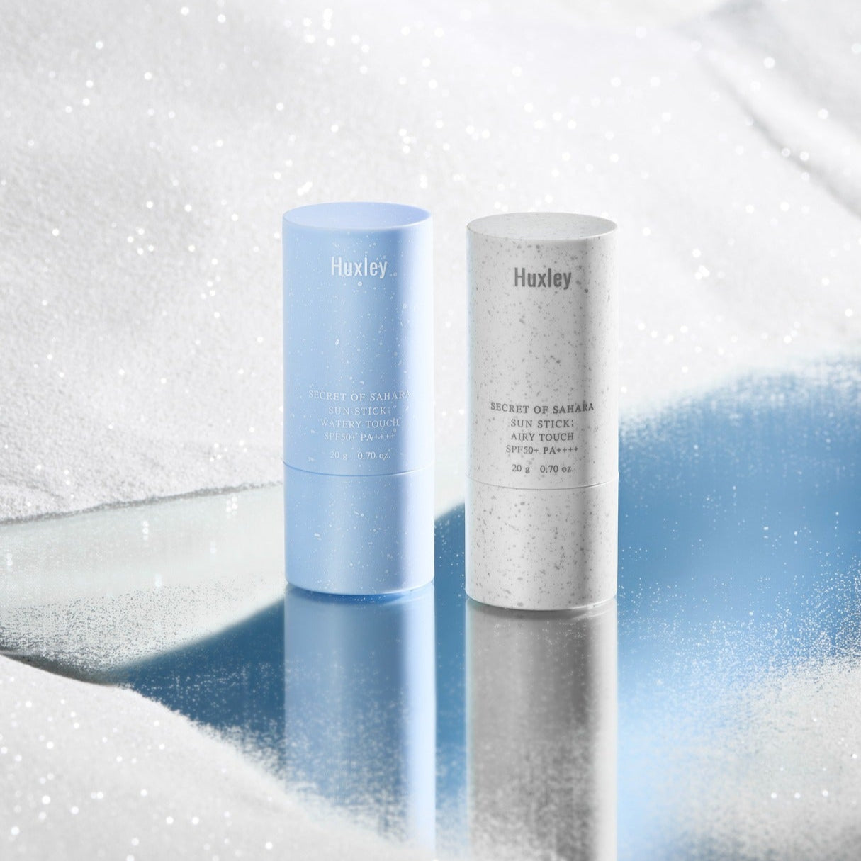 HUXLEY Sun Stick Airy Touch 20g on reflective snowy surface, featuring blue and white packaging for sun protection skincare.