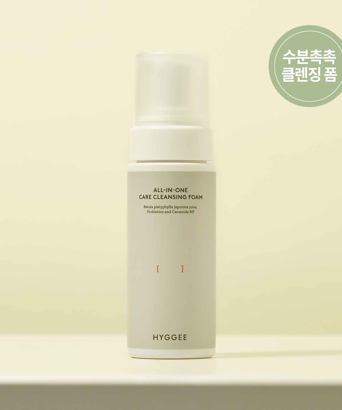 HYGGEE All-In-One Care Cleansing Foam 150ml bottle on a beige background.