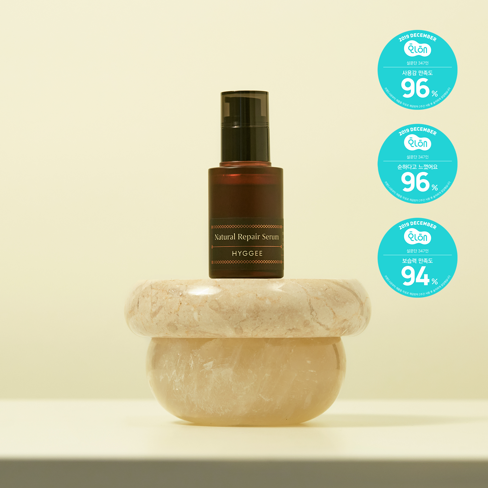 HYGGEE Natural Repair Serum 30ml bottle displayed on a marble stand with quality assurance labels, highlighting the product's features.