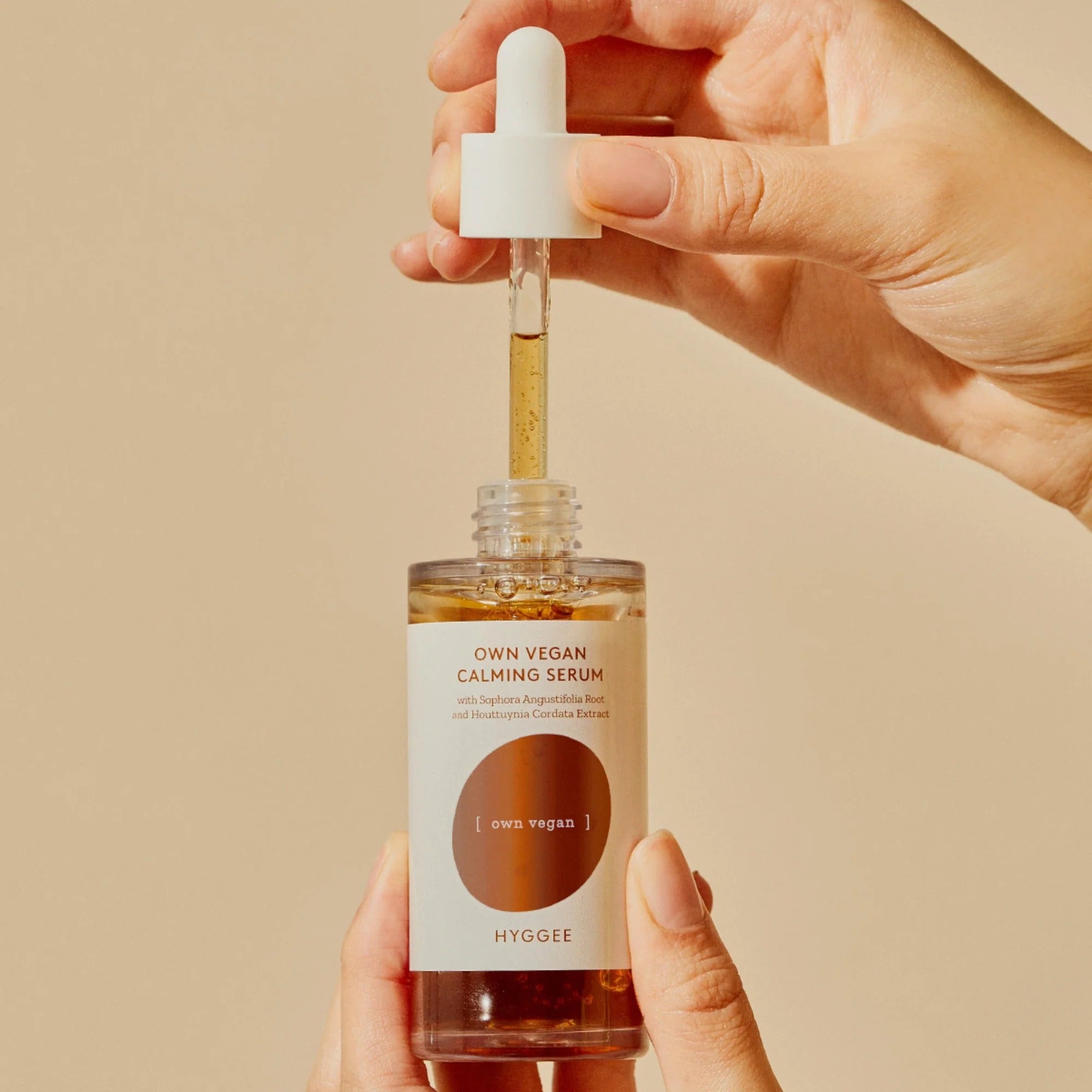 HYGGEE Own Vegan Calming Serum 50ml with dropper in hands against a neutral background.