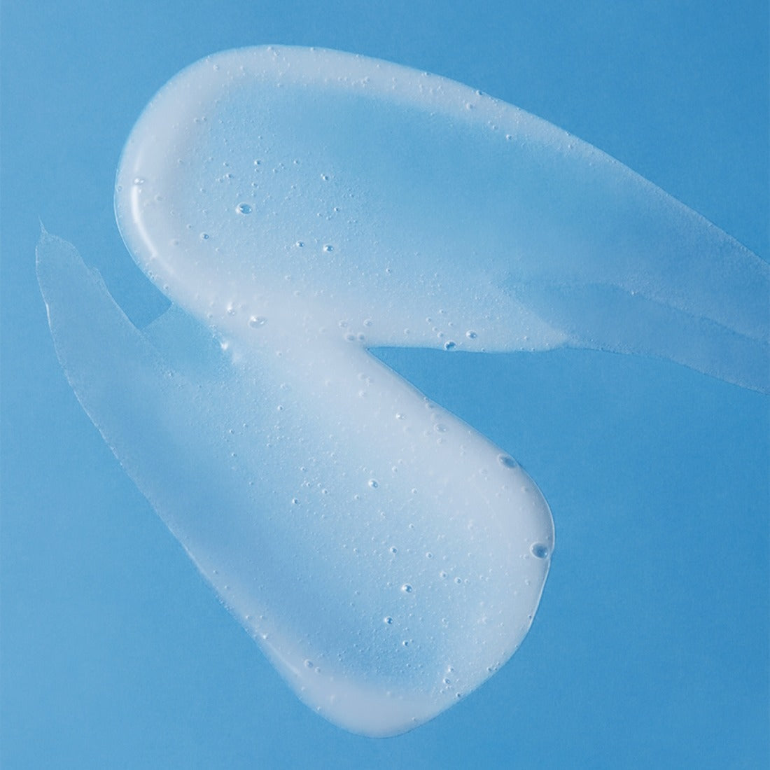 Texture of ILLIYOON Ceramide Ato 5.0 Gentle Skin Cleanser 400ml against a blue background.