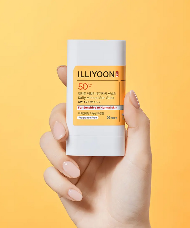 Hand holding ILLIYOON Daily Weaponless Sun Stick 20g against an orange background.