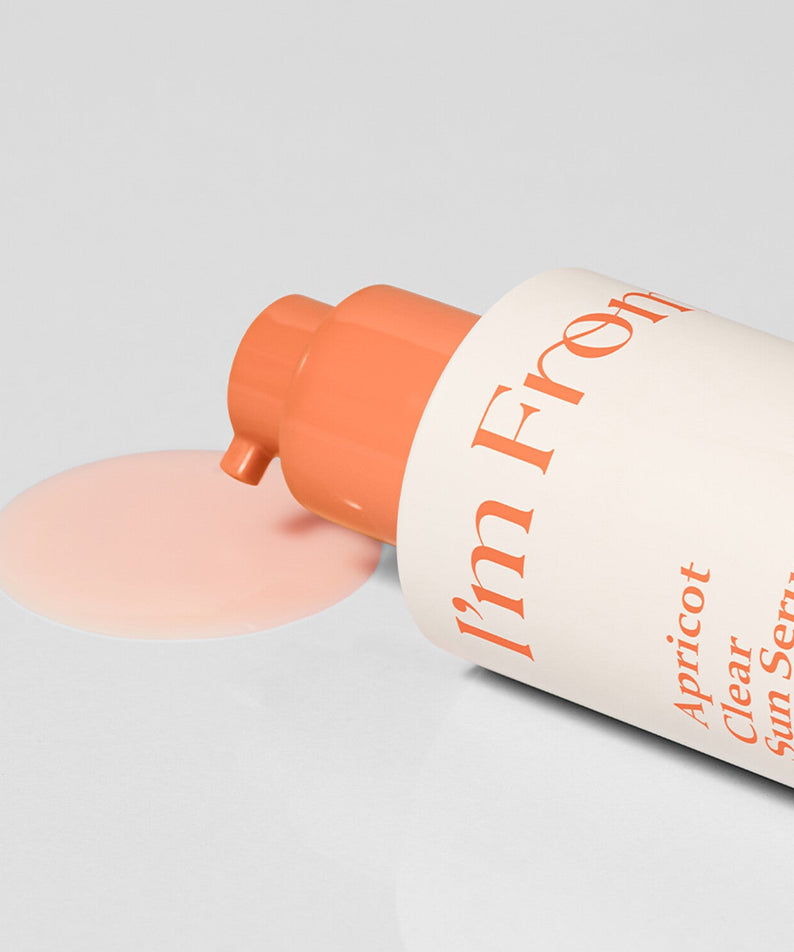 I'M FROM Apricot Clear Sun Serum 50ml bottle with open cap and spilled serum on a white surface