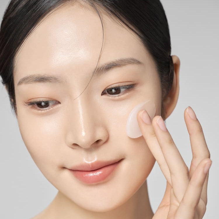 Woman applying IOPE Bio Conditioning Cleansing Oil-in-Gel 150ml to her face for smooth skincare routine