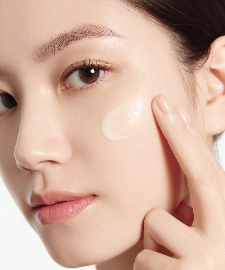 Woman applying IOPE Retinol Expert 0.1% Wrinkle Corrector 30ml Set on cheek for anti-aging skincare
