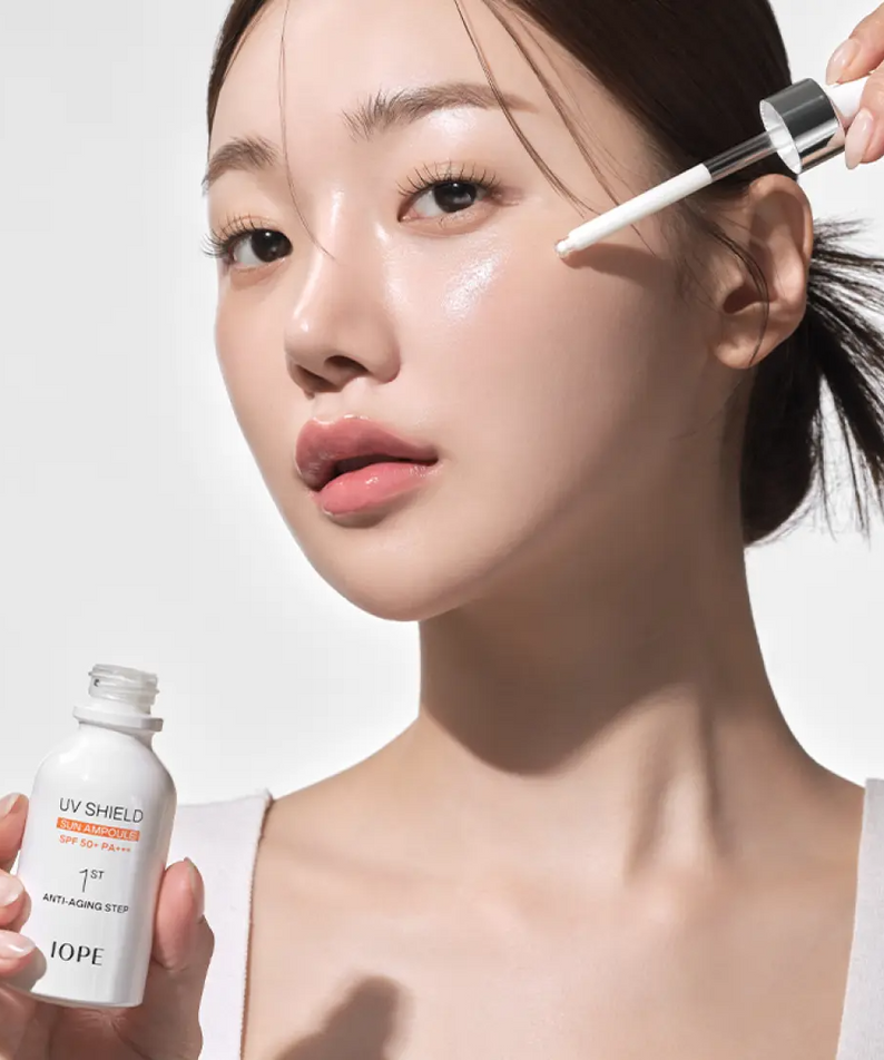 Woman applying IOPE UV Sheild Sun Ampoule SPF 50+PA+++ 40ml on her face for sun protection and skincare