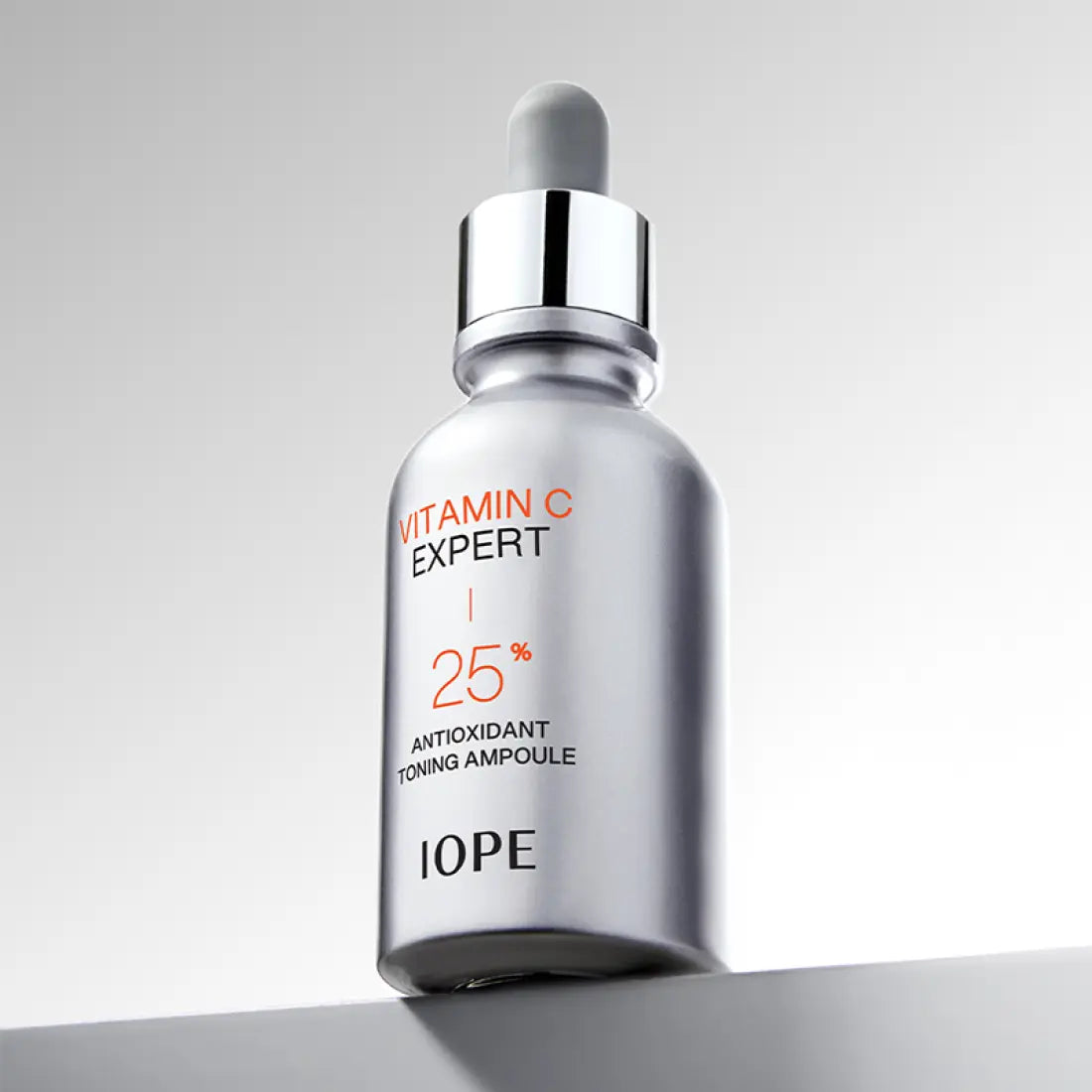 IOPE Vitamin C Expert 25% Toning Ampoule 23ml silver bottle on gray background