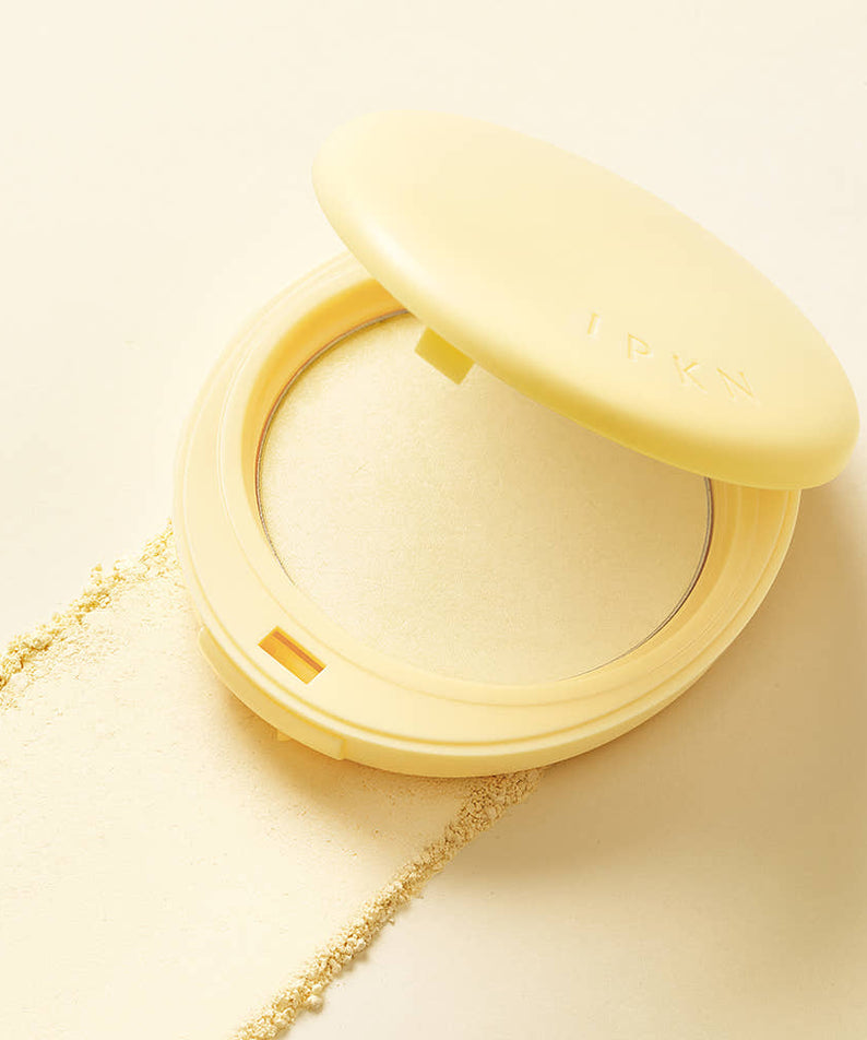 Open compact of IPKN Tonewear Primer Pact 7.5g with powder texture on beige background.