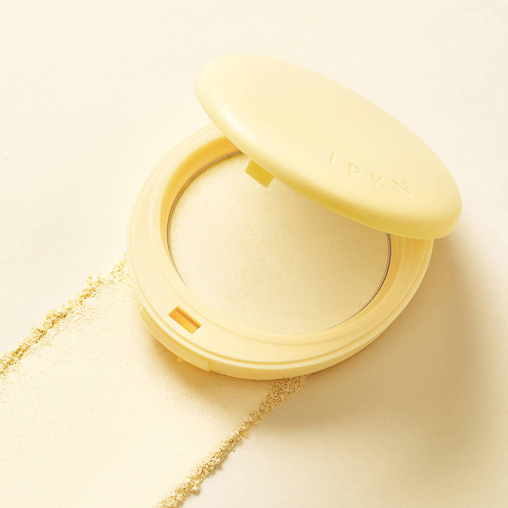 Open compact of IPKN Tonewear Primer Pact 7.5g with powder texture on beige background.