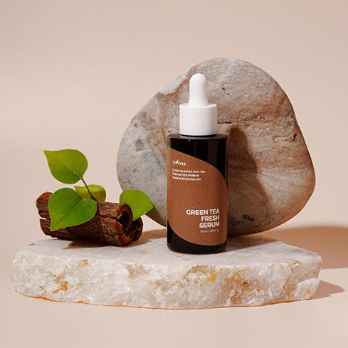 ISNTREE Green Tea Fresh Serum 50ml bottle with natural stone background, highlighting its eco-friendly and refreshing properties.