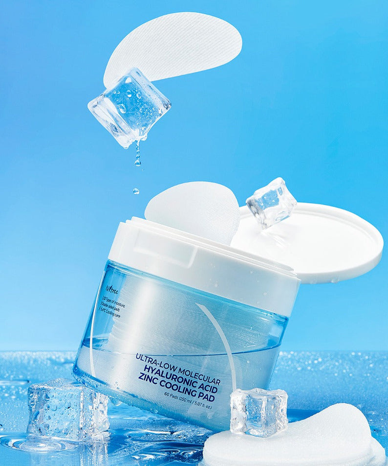 ISNTREE Hyaluronic Acid ZINC Cooling Pad 60 Sheets in open container, surrounded by ice cubes, blue background.