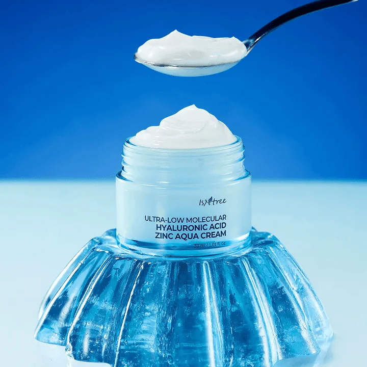 ISNTREE Hyaluronic Acid ZINC Moisture Cream 80ml in jar and spooned on blue background.