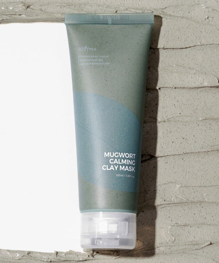ISNTREE Mugwort Calming Clay Mask 100ml tube on clay background showing packaging details.