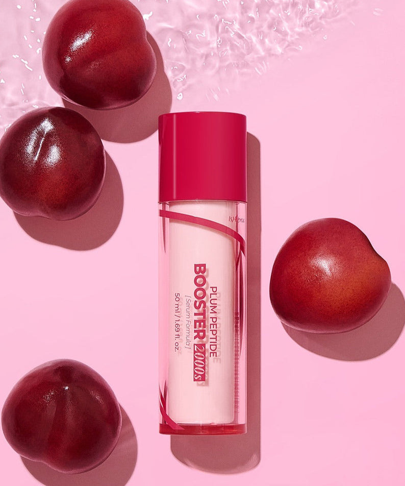 ISNTREE Plum Peptide Booster 2000s 50ml bottle surrounded by fresh plums on a pink background