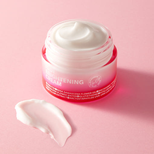 ISOI Brightening Cream 55ml in an open jar on a pink background, showcasing product texture.