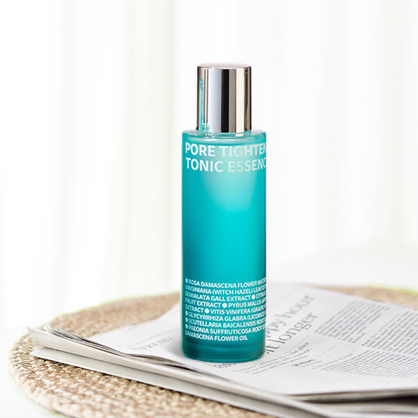 ISOI Pore Tightening Tonic Essence 130ml bottle on a table with soft lighting, showcasing skincare packaging.