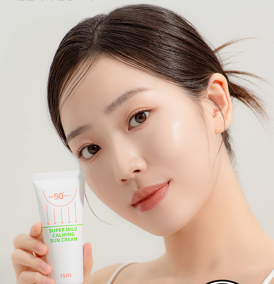 Woman holding ISOI Super Mild Calming Sun Cream SPF50+PA++++ 55ml, displaying skincare product.