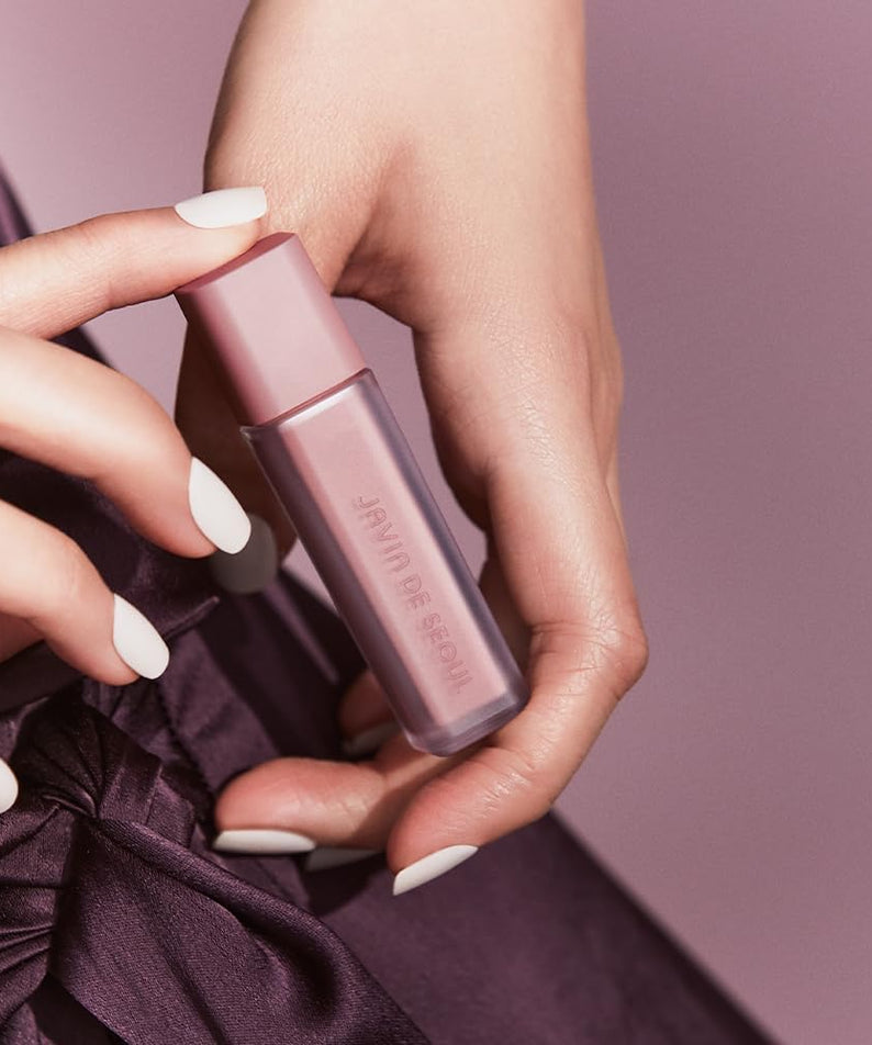 JAVIN DE SEOUL Wink Eye Shade Primer in elegant hands, featuring sleek pink packaging for perfect eye makeup base.