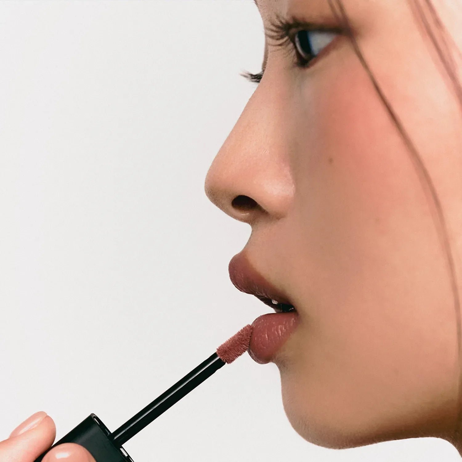 Woman applying JAVIN DE SEOUL Wink Lip Shade Primer with applicator