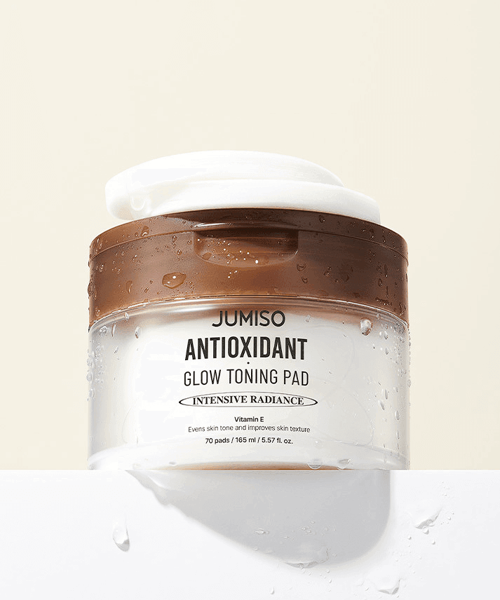 JUMISO Antioxidant Glow Toning Pads 70 Sheets container with wet surface showing packaging and branding.