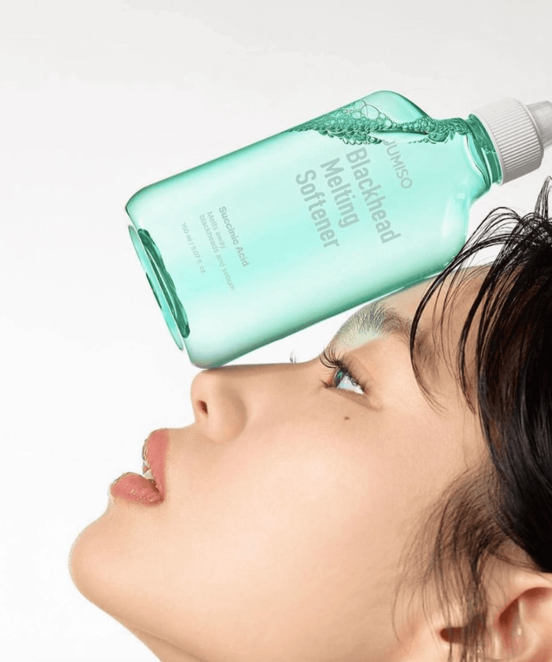 JUMISO Blackhead Melting Softener 150ml bottle balancing on woman's nose showcasing product design and packaging