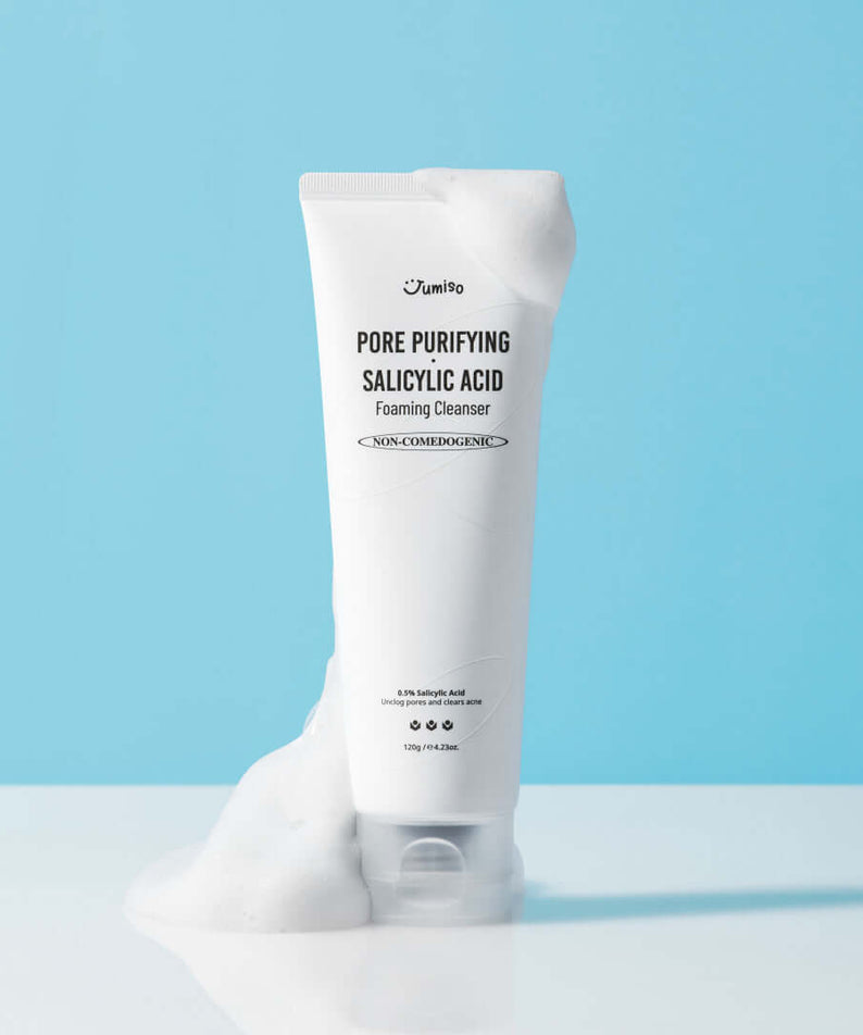 JUMISO Pore Purifiying Salicylic Acid Foaming Cleanser with foamy texture on light blue background.
