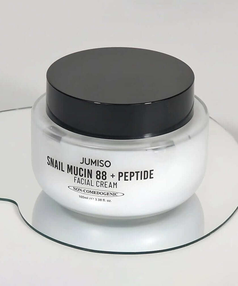 JUMISO Snail Muci 88 + Peptide Cream jar on mirror surface