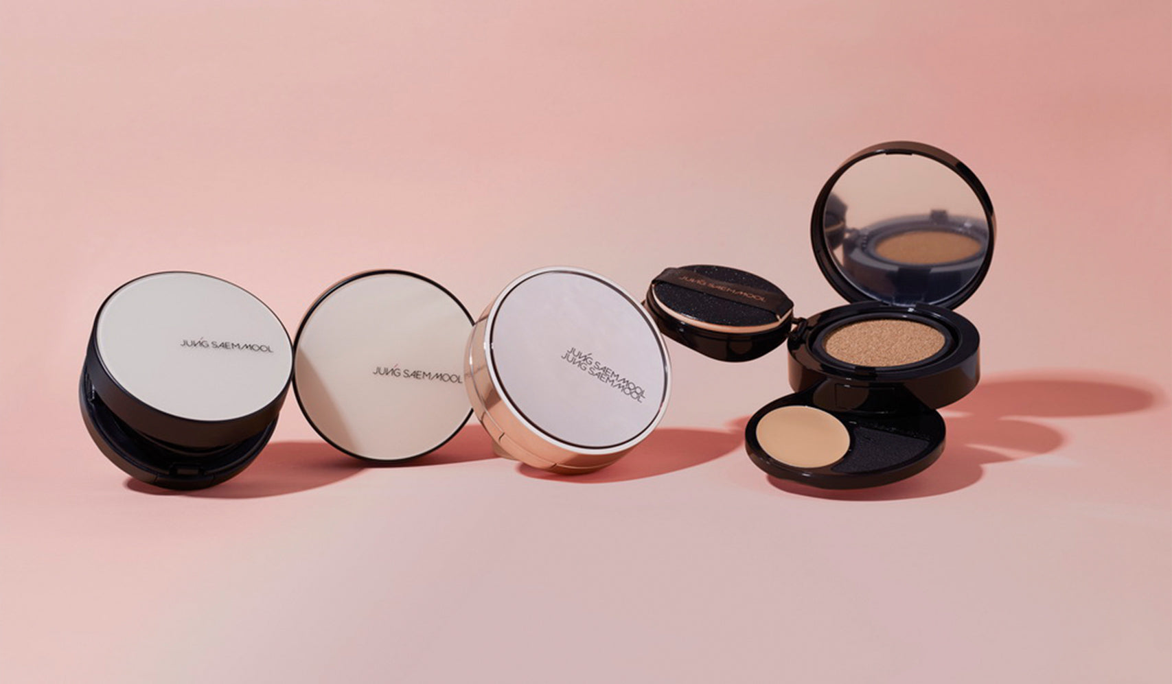 Makeup compacts on a pink background showcasing cosmetic packaging design.