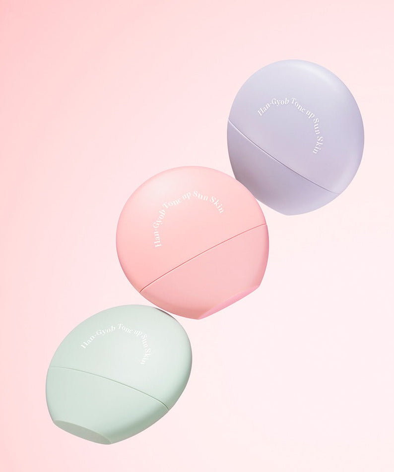 KAHI One Layer Tone-up Sun Skin 40ml bottles in pastel colors on a pink background