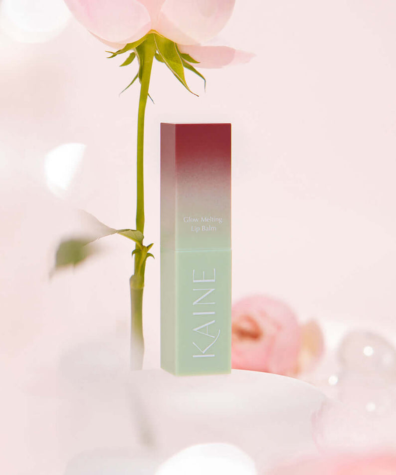 KAINE Glow Melting Lip Balm with elegant packaging and soft pink background