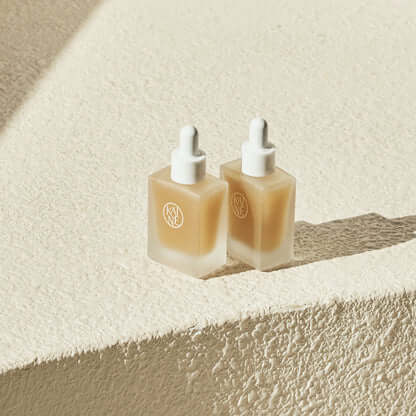 Two bottles of KAINE Kombu Barrier Ampoule on a textured surface.