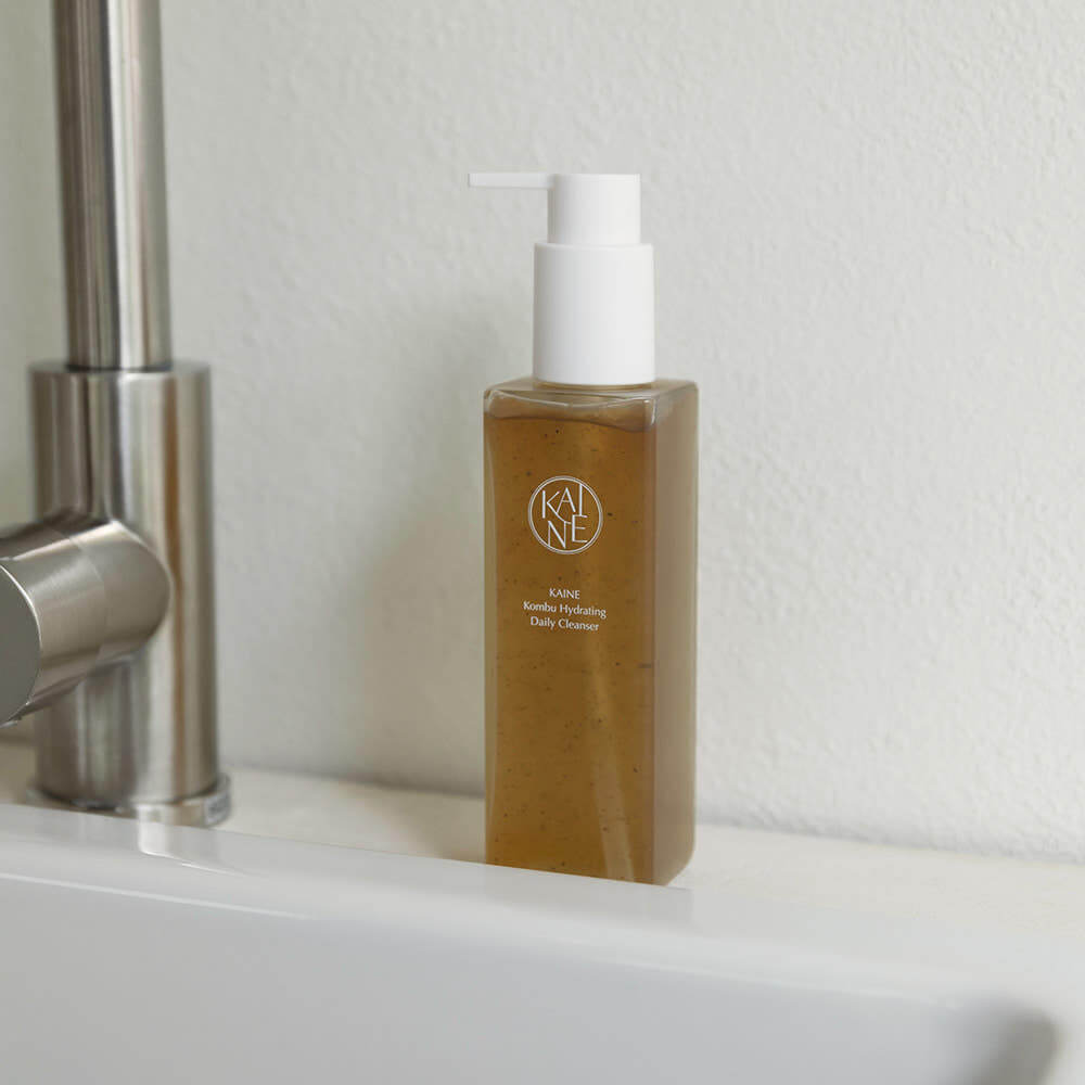 KAINE Kombu Hydrating Daily Cleanser 155g bottle on sink, promoting skincare benefits